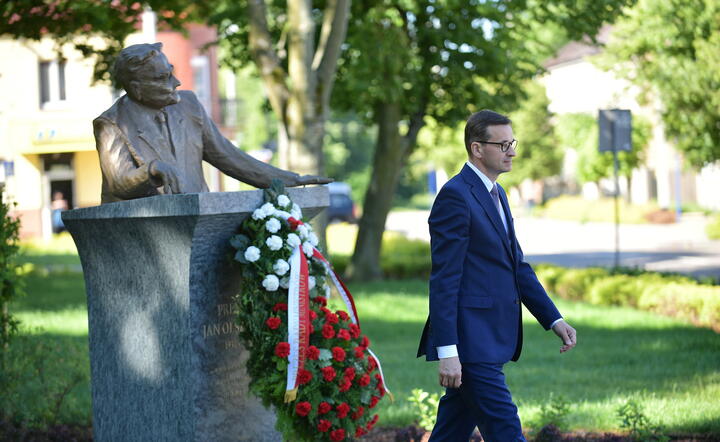 premier Mateusz Morawiecki podczas złożenia kwiatów pod pomnikiem premiera Jana Olszewskiego na rynku w Okuniewie (pow. miński) / autor: fotoserwis PAP