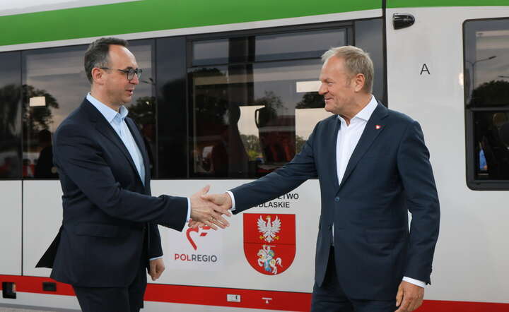 Premier Donald Tusk (P) oraz minister infrastruktury Dariusz Klimczak (L) podczas konferencji prasowej na dworcu kolejowym w Łomży, 13 czerwca 2026 / autor: PAP/Paweł Supernak