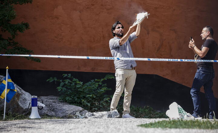 Salwan Momika, Irakijczyk, podpala kopię Koranu przed meczetem w Sztokholmie / autor: PAP/EPA/STEFAN JERREVANG