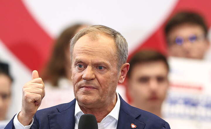 Donald Tusk na tle czerwono-białego serduszka  / autor: PAP