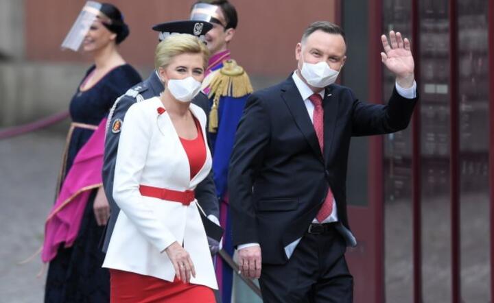Prezydent RP Andrzej Duda (P) z małżonką Agatą Kornhauser-Dudą (2L) biorą udział w uroczystości podniesienia Flagi Państwowej na Wieżę Zegarową Zamku Królewskiego w Warszawie. / autor: PAP/Radek Pietruszka