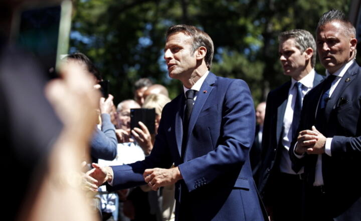 Emmanuel Macron  wita zwolenników przed głosowaniem w pierwszej turze francuskich wyborów parlamentarnych, 12 czerwca 2022  / autor: PAP/EPA/MOHAMMED BADRA