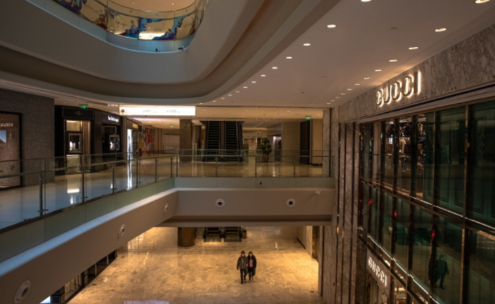 Para w maskach ochronnych chodzi po prawie pustym centrum handlowym, w dzielnicy Central Business District  w Pekinie, Chiny, 21 lutego 2020 r. / autor: PAP/EPA/ROMAN PILIPEY