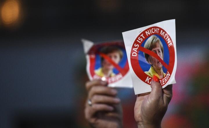 Na wiecu przedwyborczym CDU z udziałem Angeli Merkel w Monachium ludzie trzymali w rękach plakietki odrzucające jej politykę / autor: Fot. PAP/EPA/CHRISTIAN BRUNA 