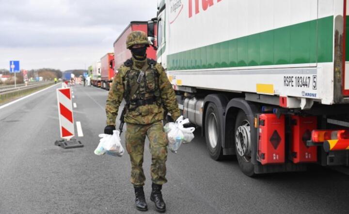 Koronawirus w Polsce. Żołnierze 12BZ przekazują wodę i żywność dla oczekujących na polsko-niemieckiej granicy w Kołbaskowie. / autor: PAP/Marcin Bieleck