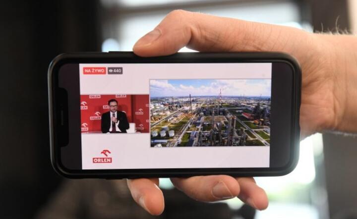Prezes zarządu PKN ORLEN Daniel Obajtek (na ekranie smartfona) podczas transmisji briefingu prasowego z udziałem wicepremiera Jacka Sasina dot. planów przejęcia Grupy Energa, 27 bm. w Gdańsku. / autor: PAP/Marcin Gadomski