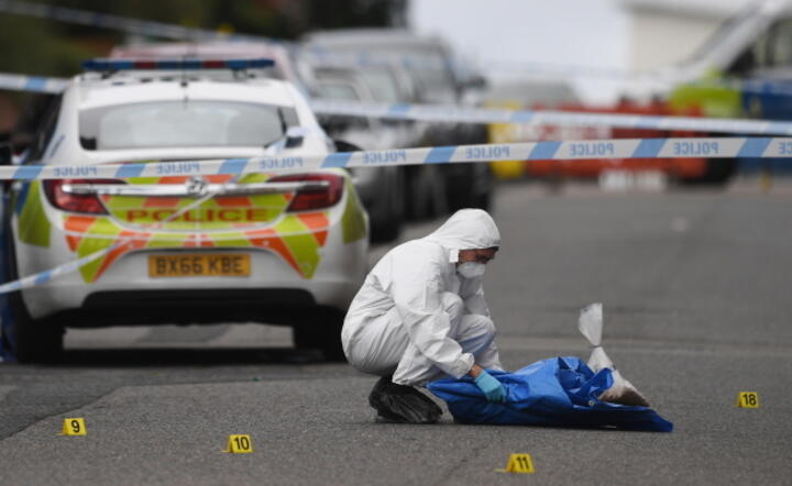 Oficer dochodzeniowy brytyjskiej policji bada ślady na ulicy w centrum Birmingham / autor: PAP/ EPA/NEIL HALL